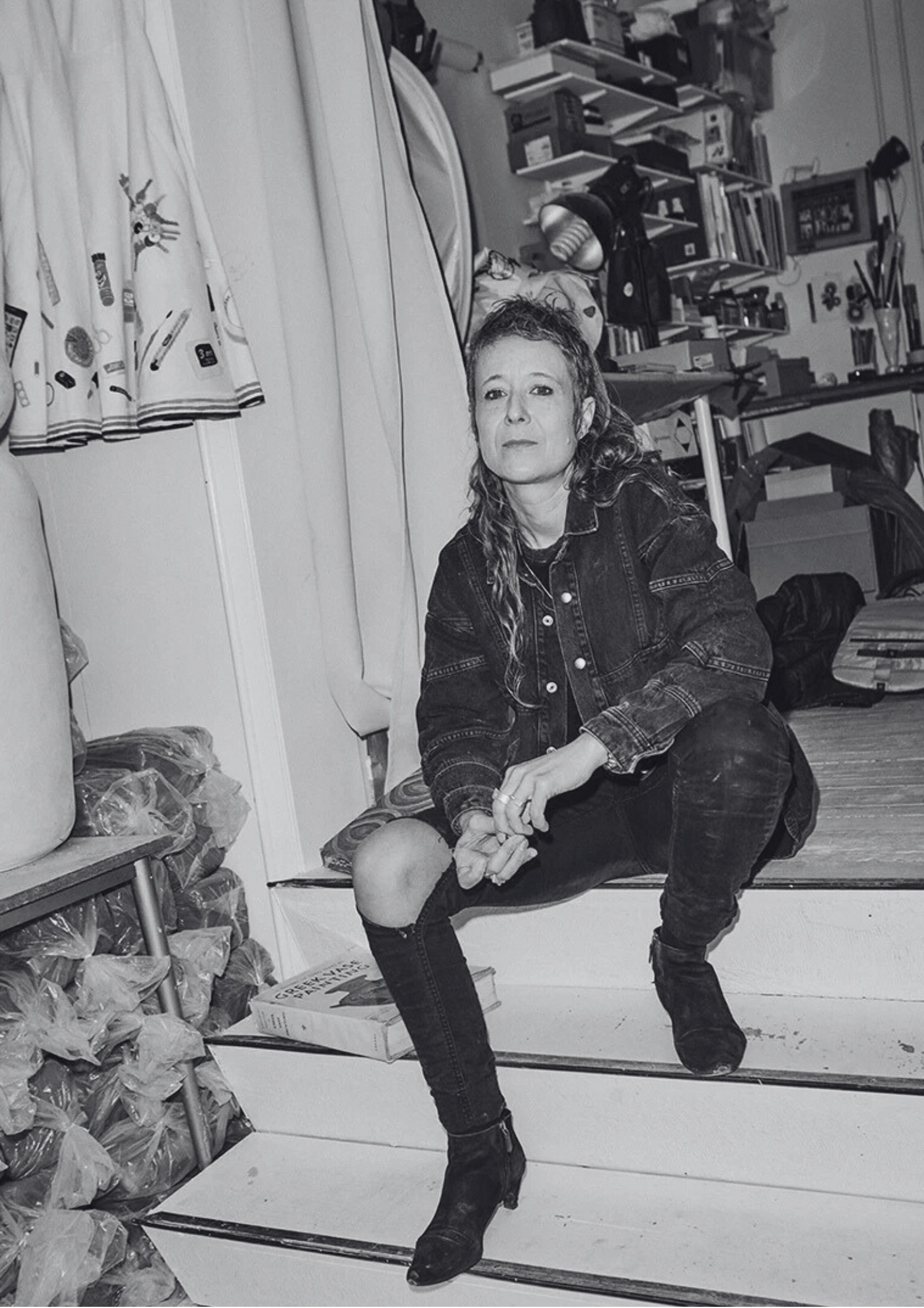 Rose Eken, Danish visual artist, sitting on stairs in her studio.